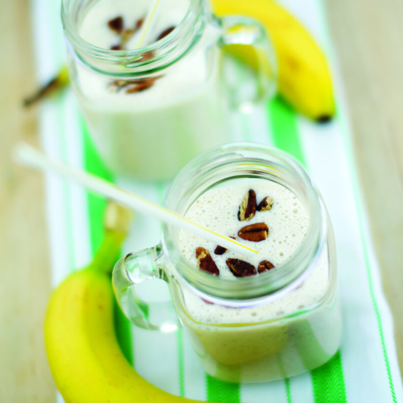 A creamy maple oatmeal smoothie served in a glass, garnished with a sprinkle of oats and a drizzle of maple syrup.