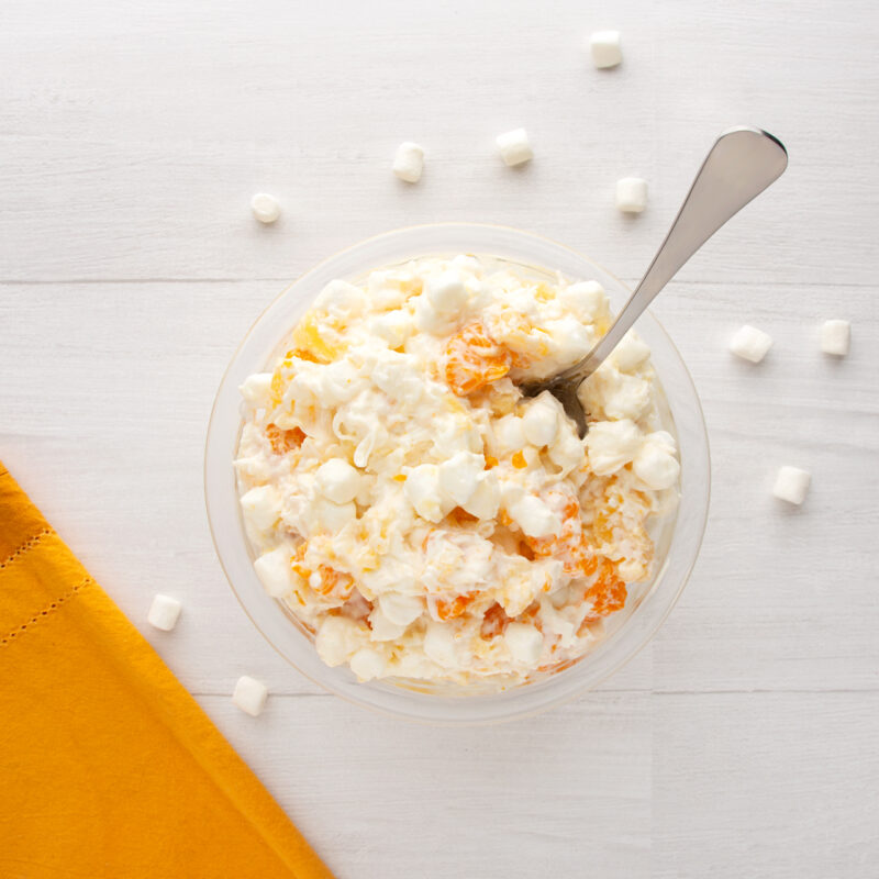 Bowl of Easy Ambrosia Salad with fruit and whipped cream
