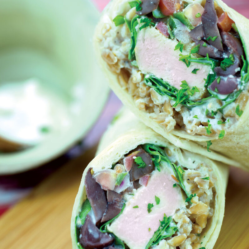 Mediterranean wrap filled with fresh vegetables, hummus, and grilled chicken.