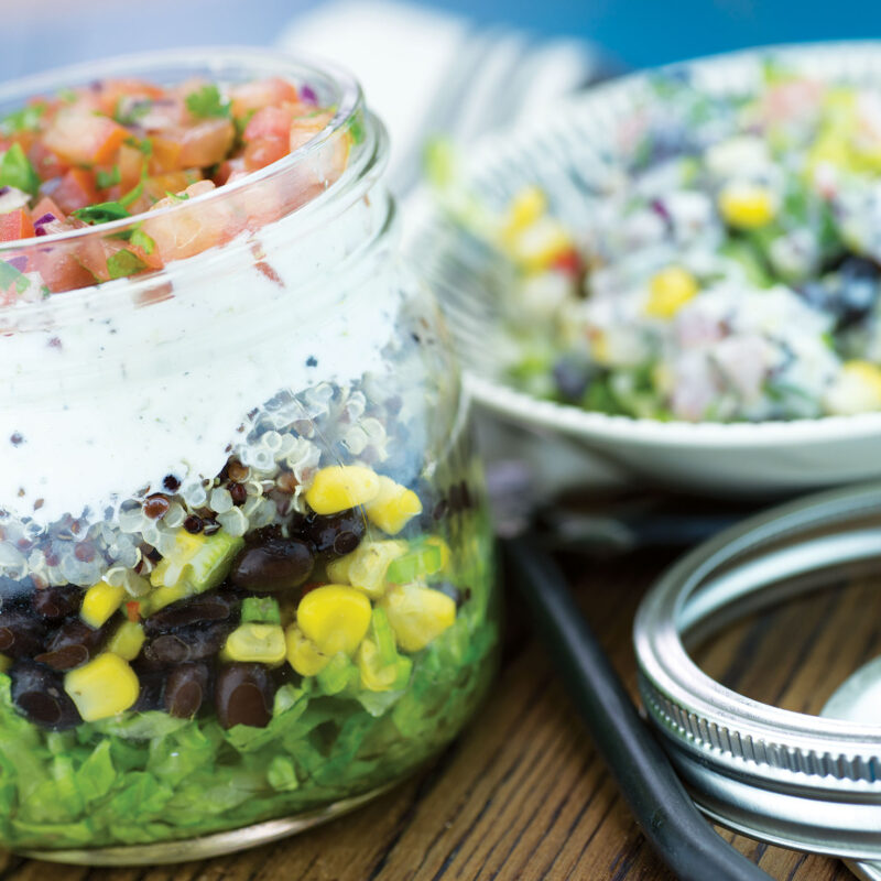 Spicy salad shaker with fresh vegetables and a tangy dressing in a shaker cup.