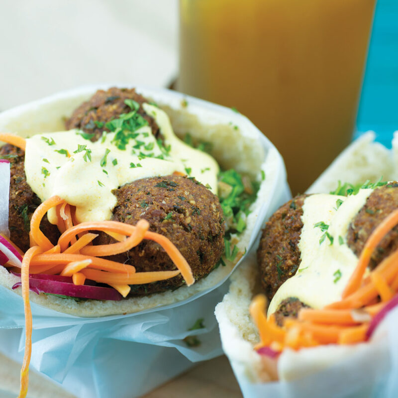 Super falafel wrap filled with falafel, fresh vegetables, and sauce, wrapped in a soft pita.